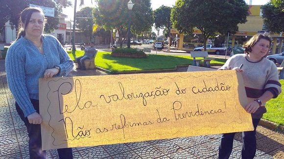 Imagem: JB Treinamento / Educadoras do Município de Jussara exibem faixa em praça pública defendo direitos da classe trabalhadora "Pela valorização do cidadão. Não as reformas da Previdência ". 